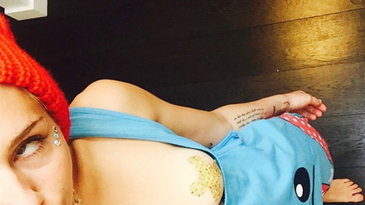 Miley Cyrus har plåster på brösten. 